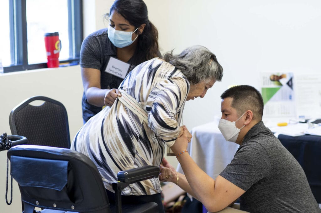 Two entry-level occupational therapy students work with a patient