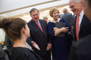 From left to right, Douglas Ivester, Kay Ivester and Brenau President Ed Schrader react to seeing the new scrubs for students of the Mary Inez Grindle School of Nursing during the dedication of the Mary Inez Grindle School of Nursing. (AJ Reynolds/Brenau University)