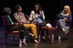 four women in chairs on stage for Women's Leadership Colloquium