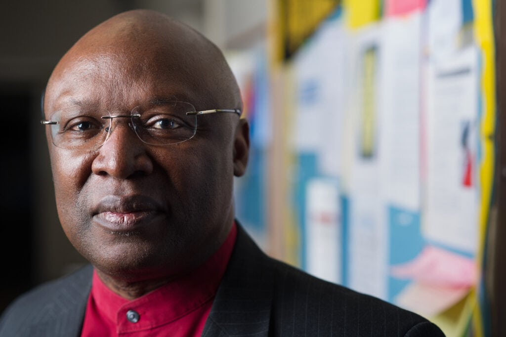 A headshot of Eugene Williams, in front of a school bulletin board