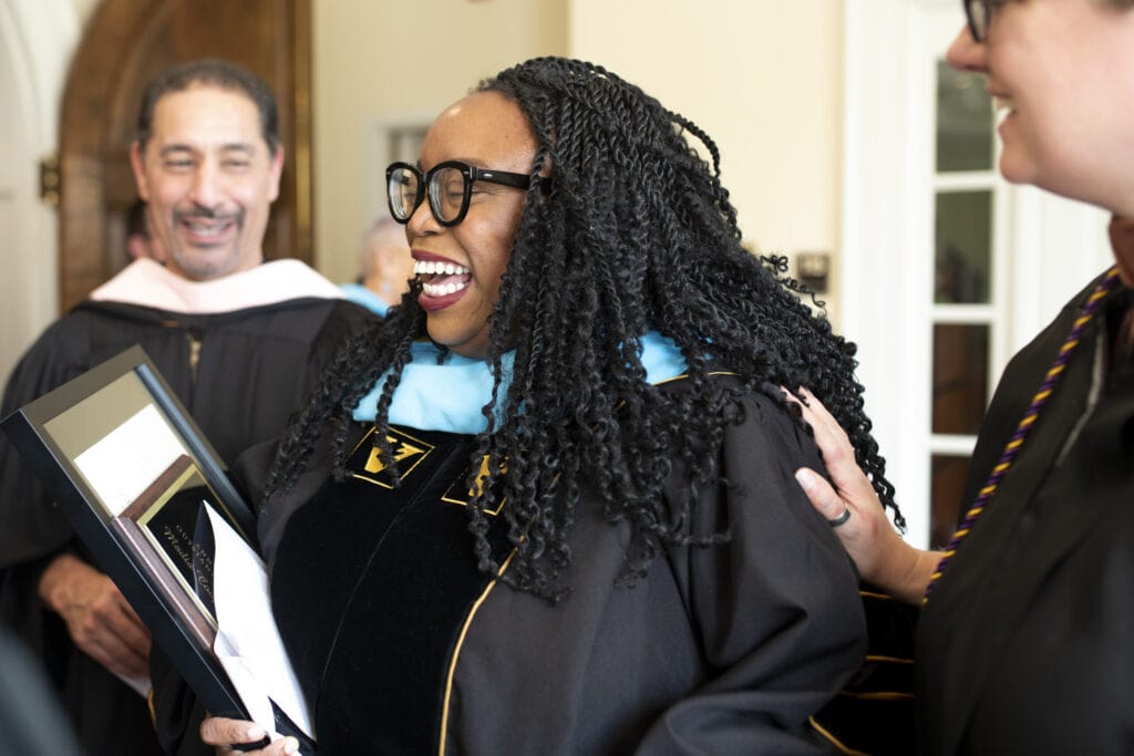 Madia Cooper-Ashirifi smiles while wearing her academic regalia.