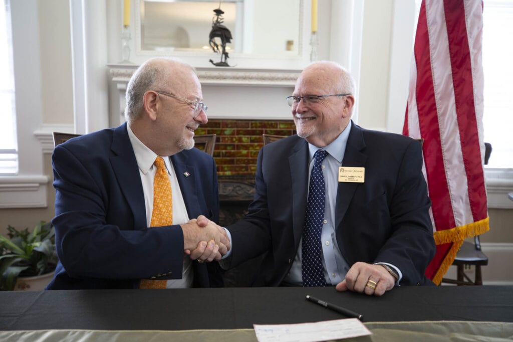 Javier Díaz de León and David Barnett shake hands after the grant agreement signing.