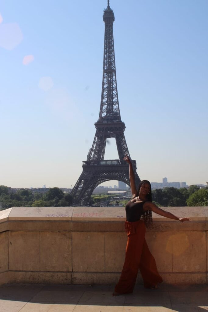 Laila Glover in a dance pose in front of the Eiffel Tower