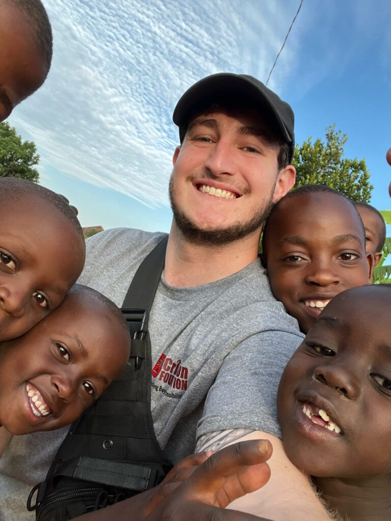 A male student takes selfies with children