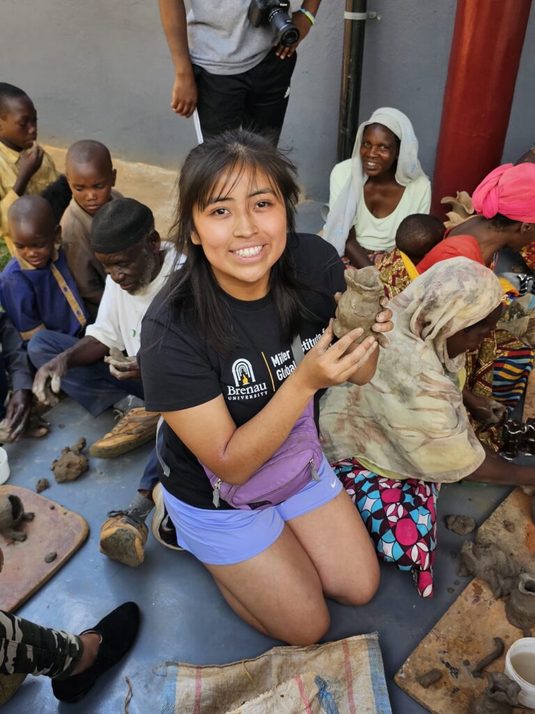 A female student holds up pottery in Rwanda