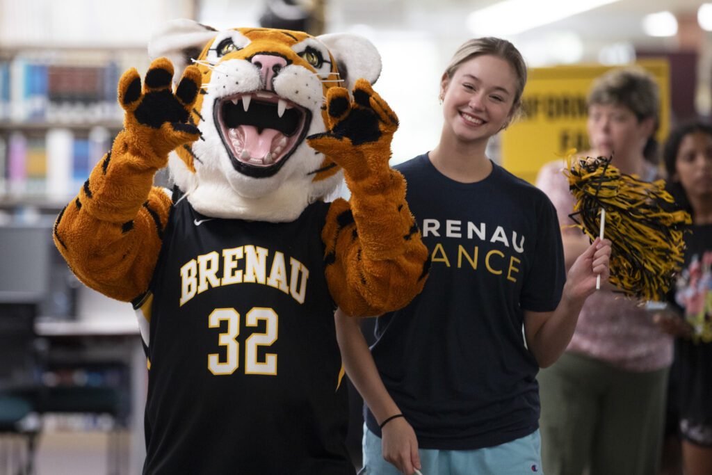 HJ the Tiger poses with a dance student at summer orientation