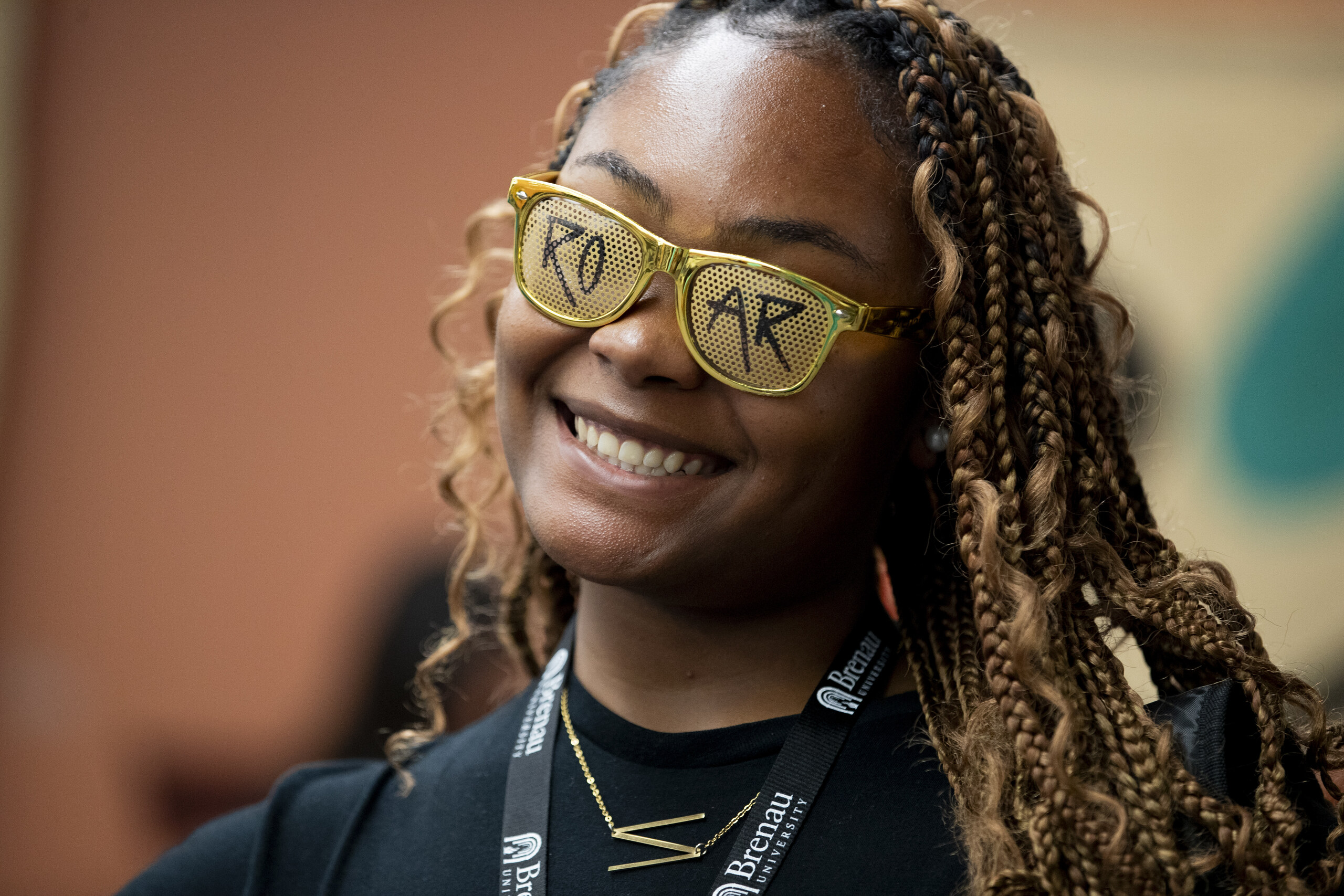 A student wears specialty sunglasses with the ROAR logo on the lenses