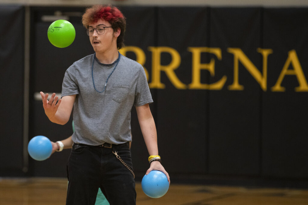 A male student juggles at summer orientation