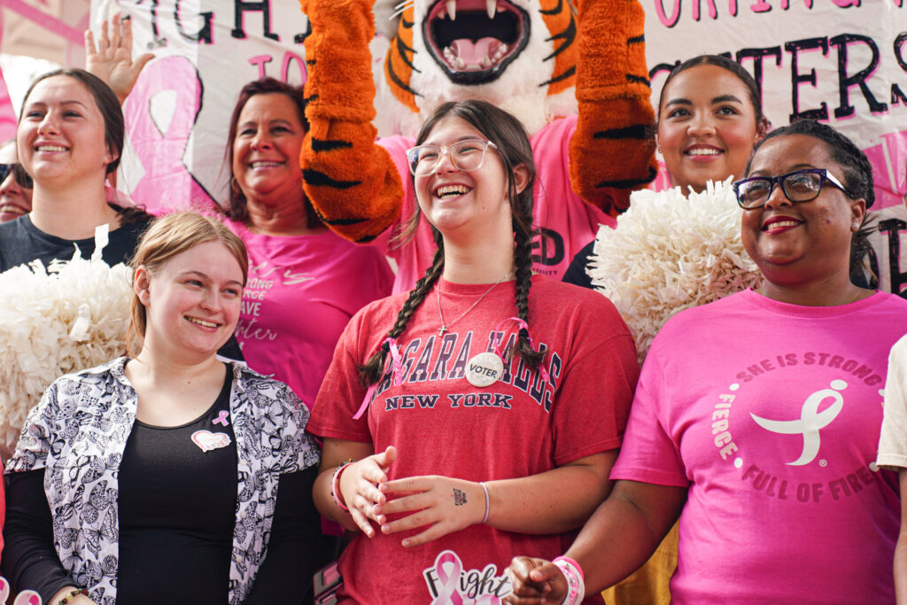 students and faculty smile for a photo at the annual pink out