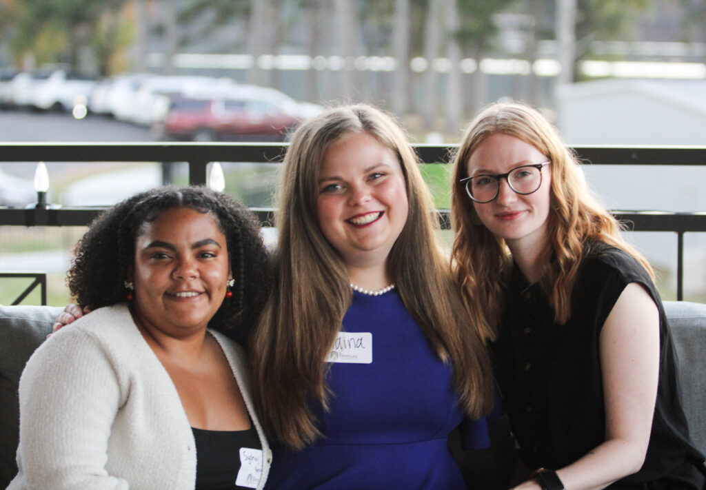 Three new alums pose for a photo