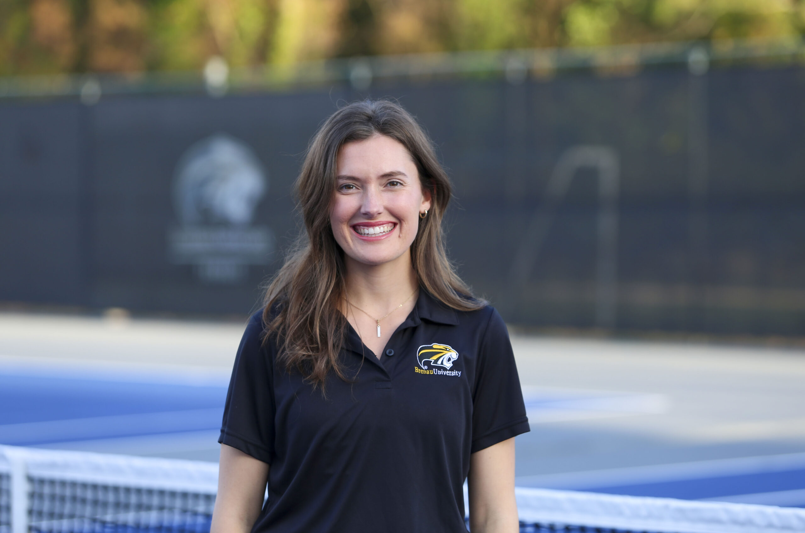 Kathryn Barker stands in front of the Brenau tennis court