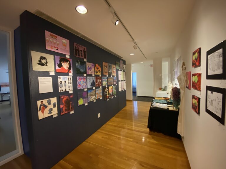 Paintings and drawings on a black wall at the High Museum